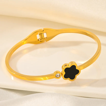 Gold bracelet with a black clover-shaped clasp 