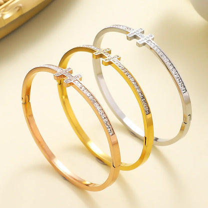 Stainless steel bangle featuring a zirconia-encrusted  H motif and sparkling stone row along the band
