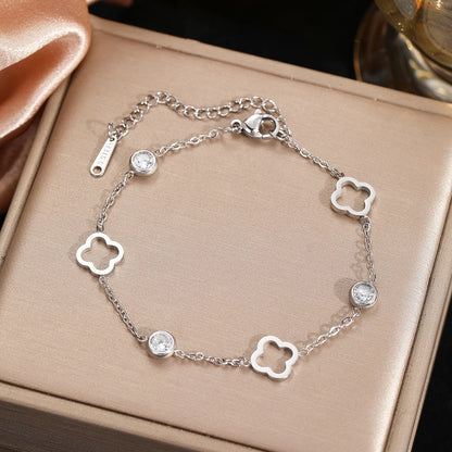 Silver bracelet with clover-shaped links on a beige box