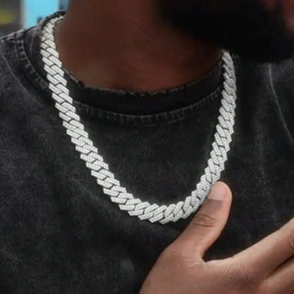 Man  wearing a silver chain necklace  on a grey shirt 