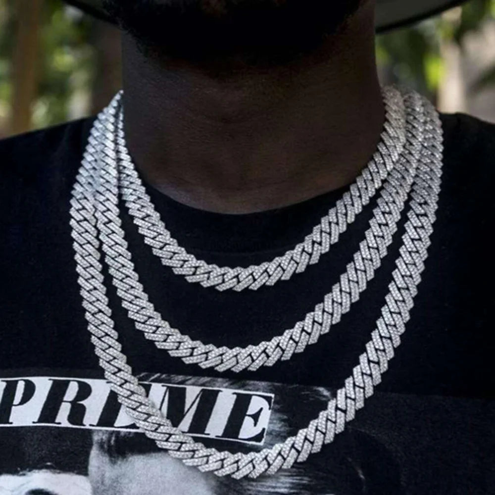 Person wearing multiple silver necklaces with a blurred background