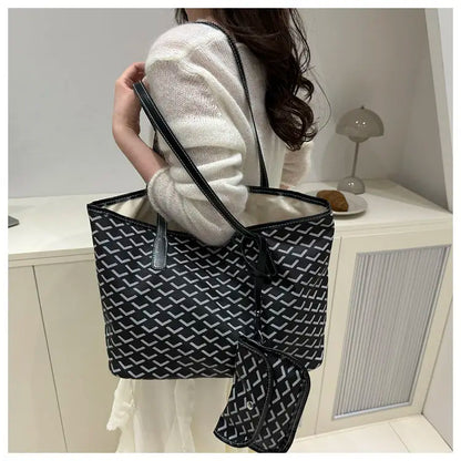 Person holding a black and white patterned tote bag in a minimalistic room.