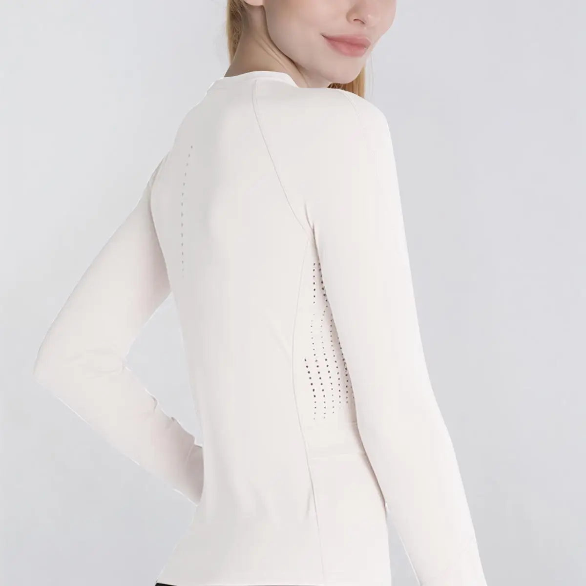 Perforated ventilation panels on sides of long sleeve workout top
