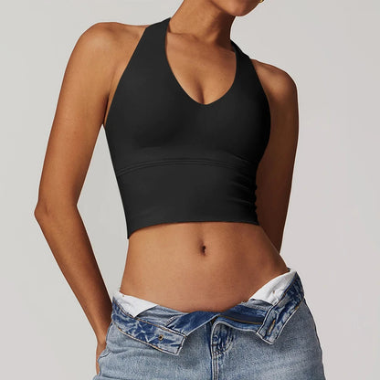 Person wearing a black crop top and blue jeans 