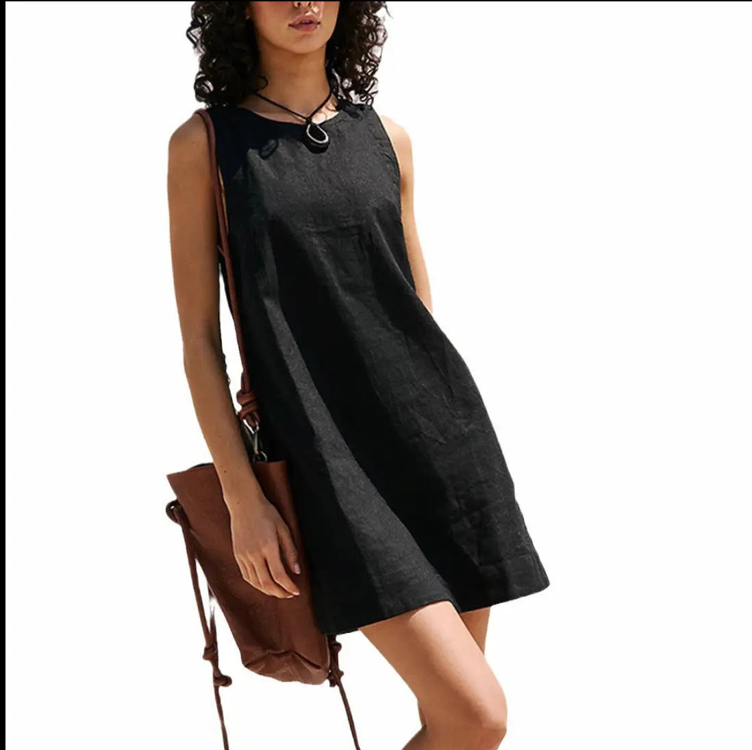 Woman wearing a black sleeveless dress holding a brown bag 