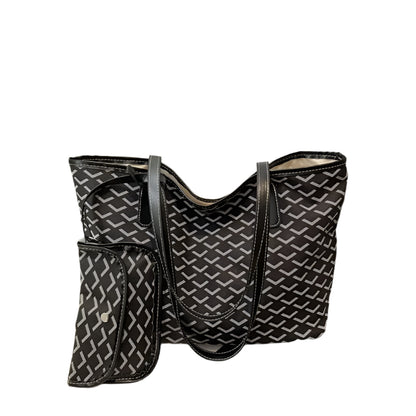 Black and white patterned handbag on a surface with a blurred background