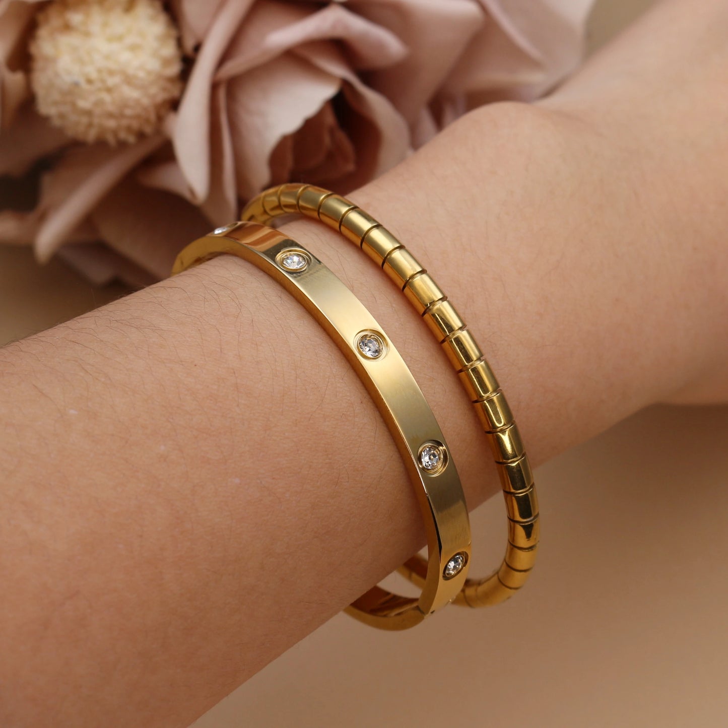 Stacked gold bangles on wrist – smooth and ribbed stainless steel bracelet set
