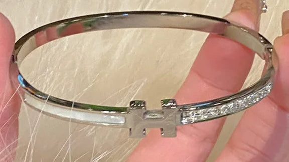 Silver  H bracelet with a brand logo 