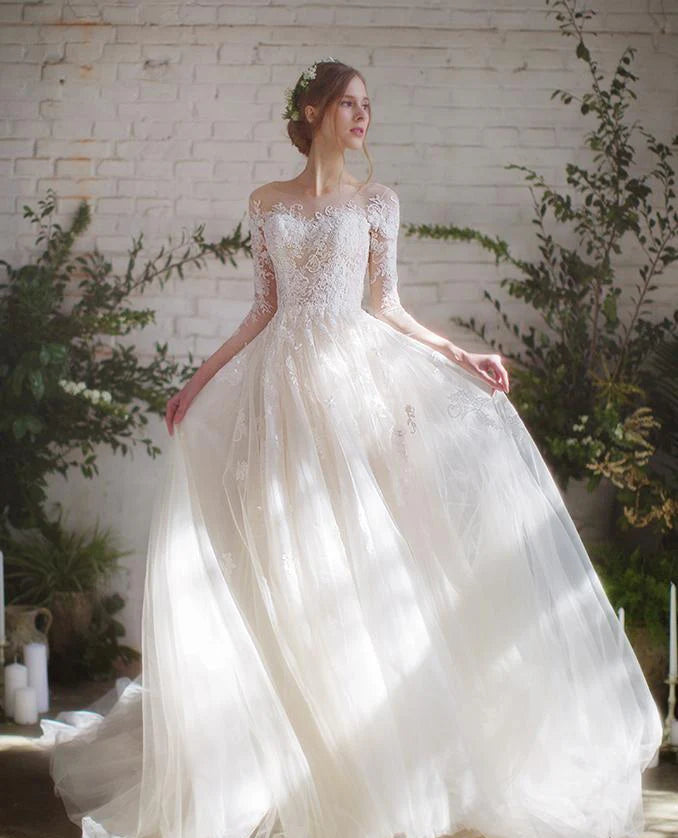Woman wearing a white wedding dress with intricate detailing in a rustic setting.