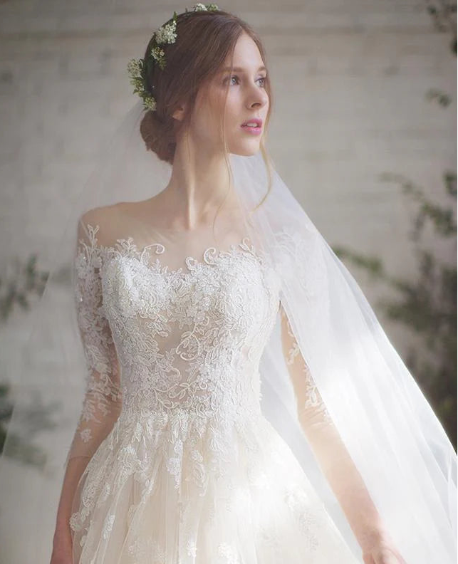 gorgeous wedding gown features a wide illusion neck that highlights your decolletage. 