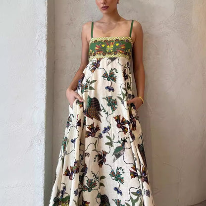 Close-up of botanical and bird motif print on cream polyester maxi dress`
