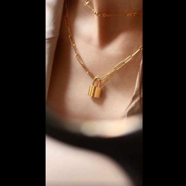 Close-up of padlock charm on long punk chain