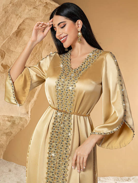 Woman wearing a gold dress with intricate detailing 