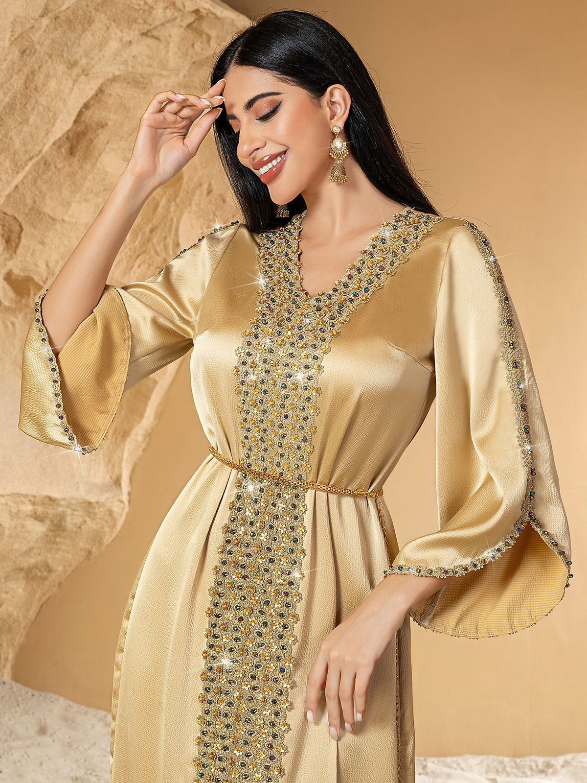Woman wearing a gold dress with intricate detailing 