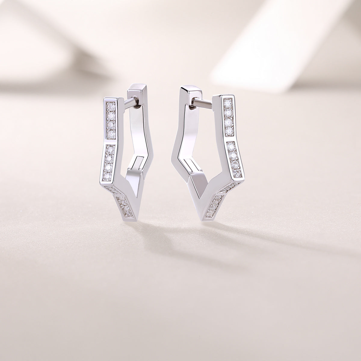 Pair of silver hoop earrings with embedded moissanite stones 