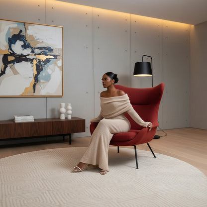 Woman in a beige off-shoulder outfit sitting on a white chair 