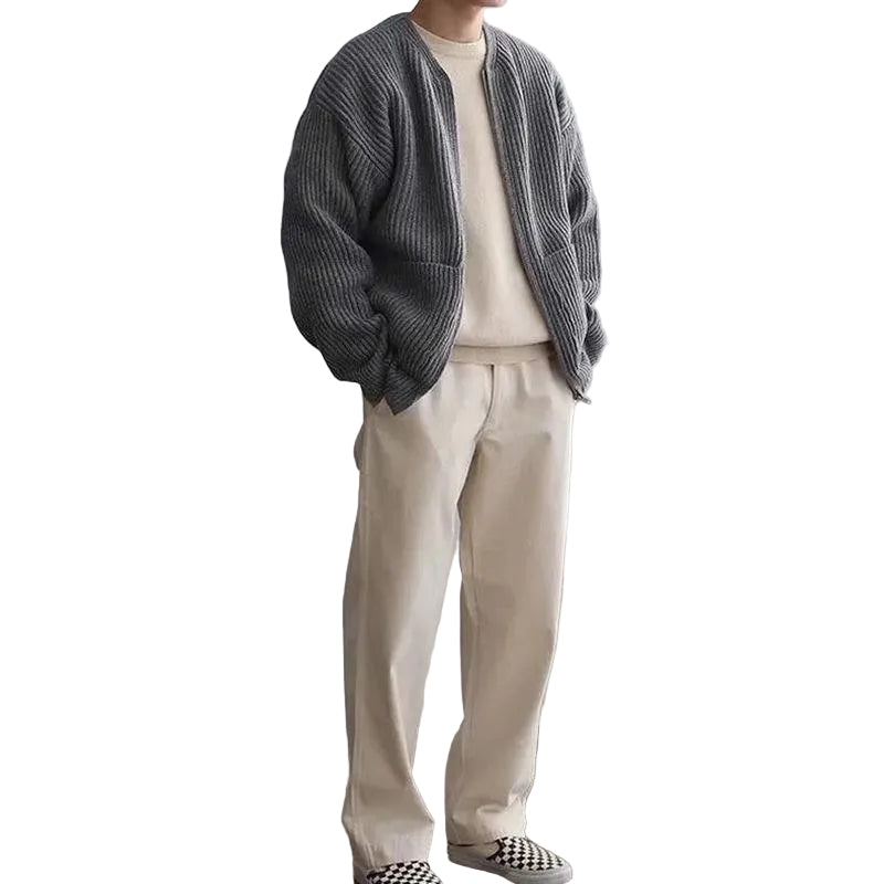 Person wearing a gray cardigan, beige sweater, and beige pants .