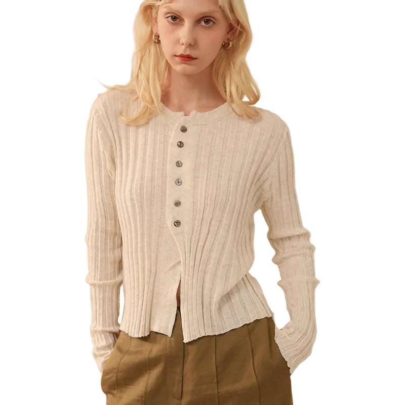 Woman wearing a cream ribbed sweater with button details 