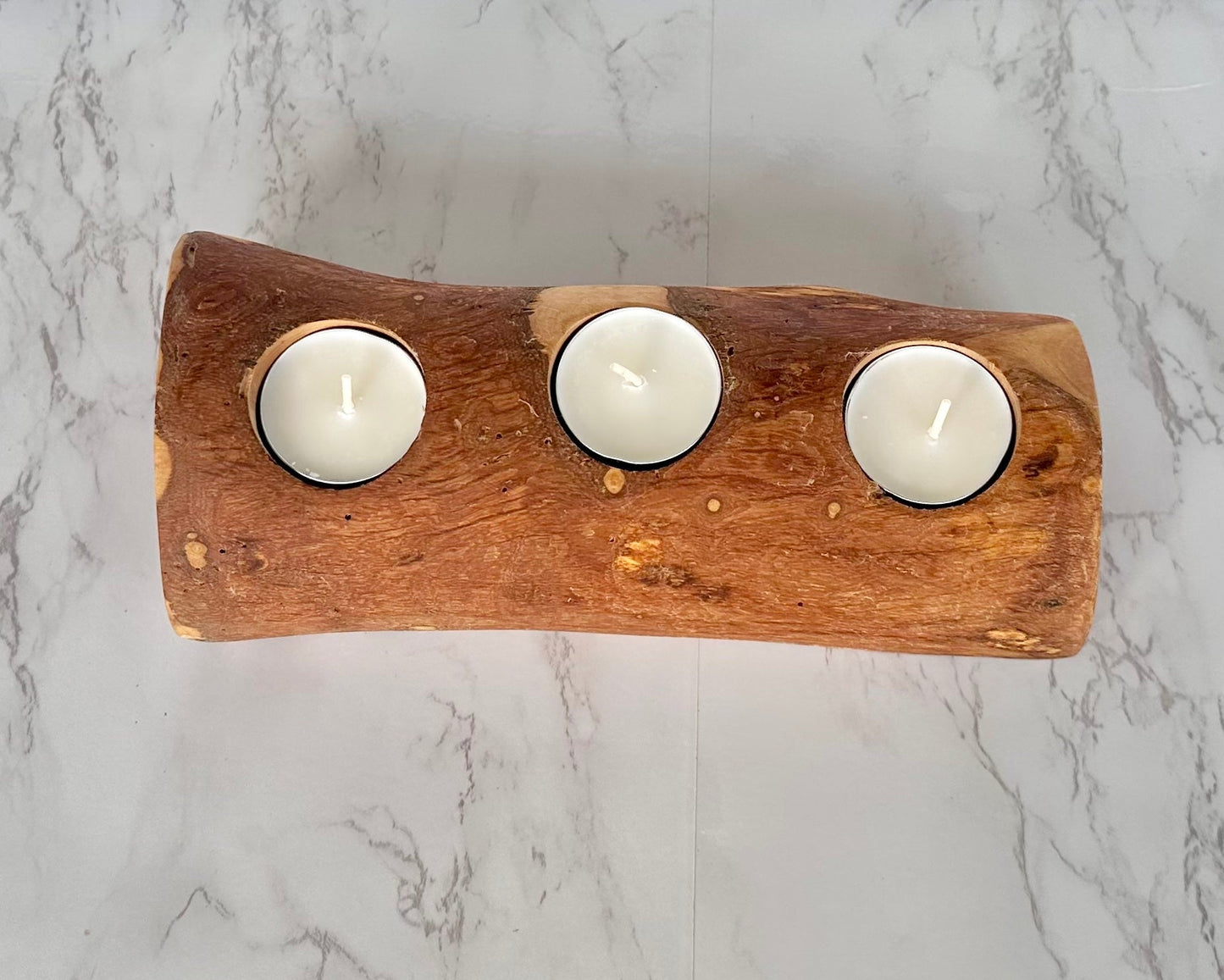 Wooden candle holder with three white candles 