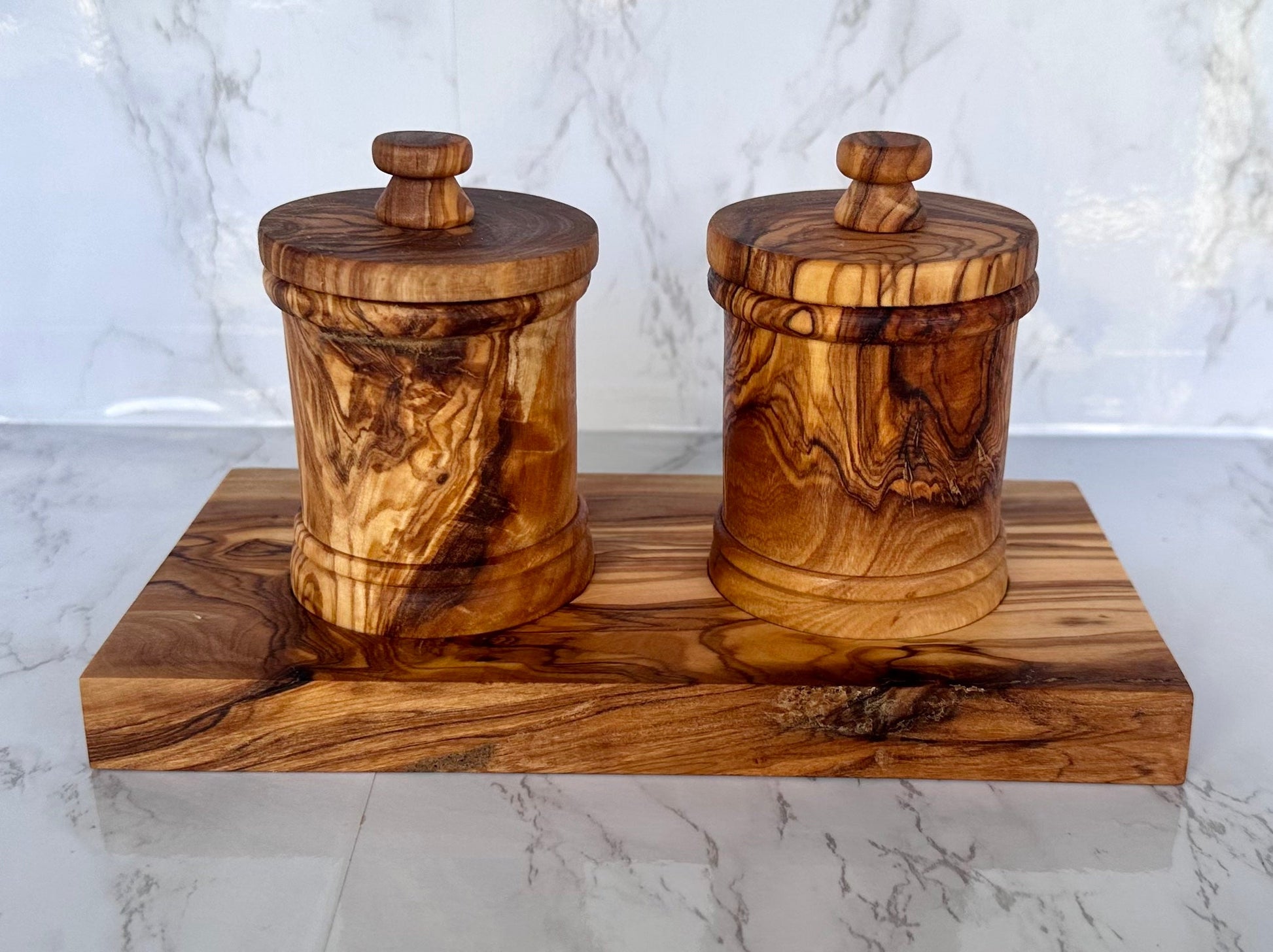 Two wooden canisters with lids on a wooden block 