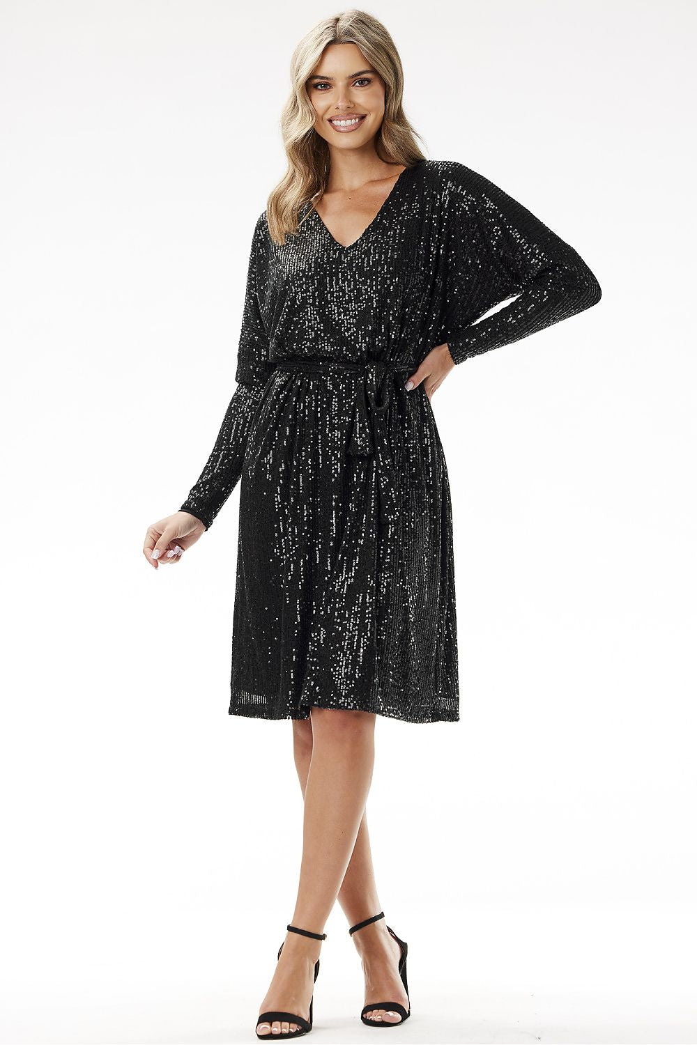 Woman wearing sequin trapeze midi dress by Awama – shimmering outfit for New Year’s Eve celebration