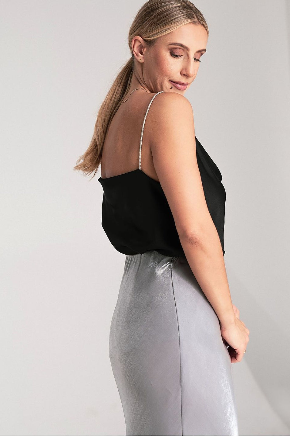 Woman wearing a  luxurious black top and light gray skirt for special  occasions events 