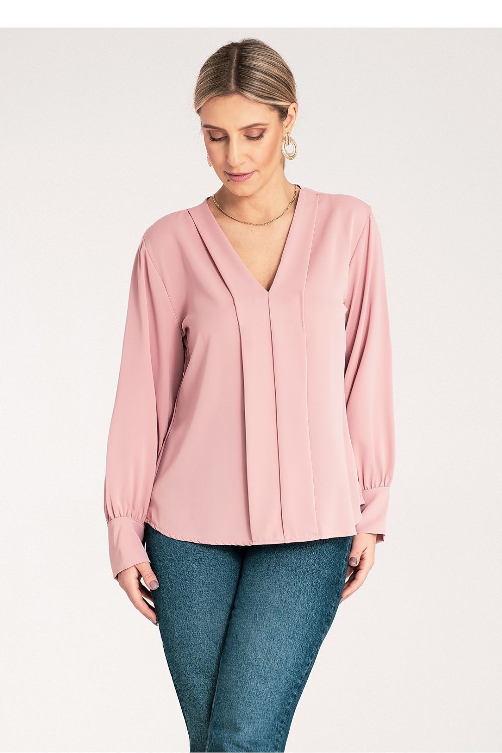 Woman wearing a pink blouse and blue jeans 