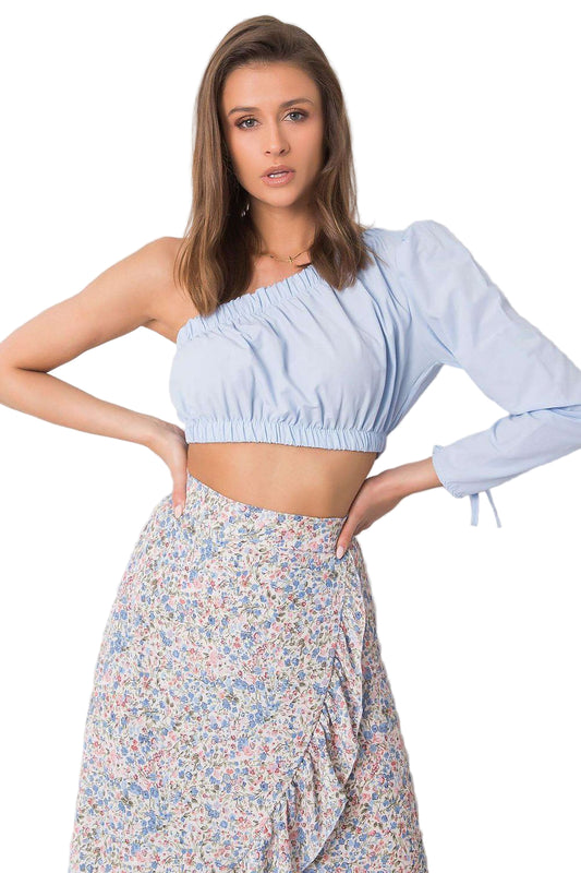 Woman wearing a light blue one-shoulder top and floral skirt 