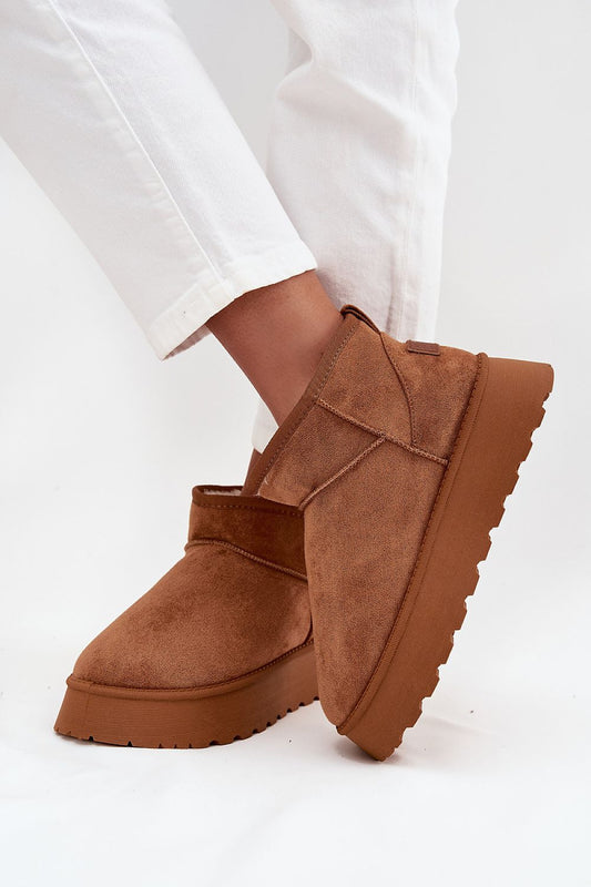 Brown platform boots worn with won a white background