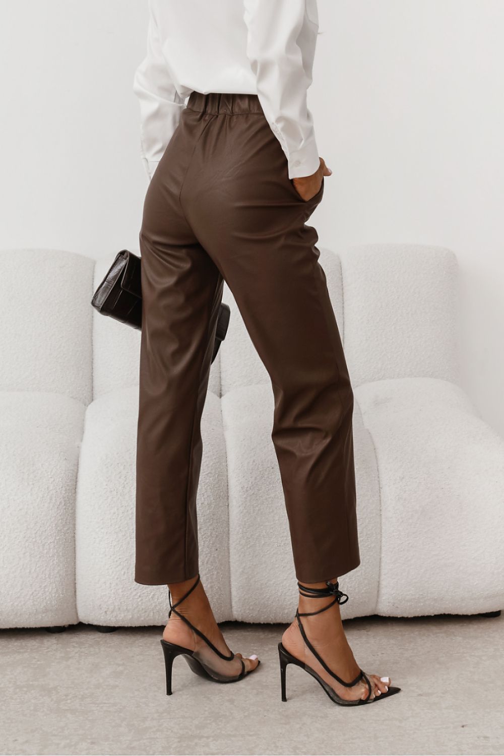 Person wearing brown pants and high-heeled shoes 