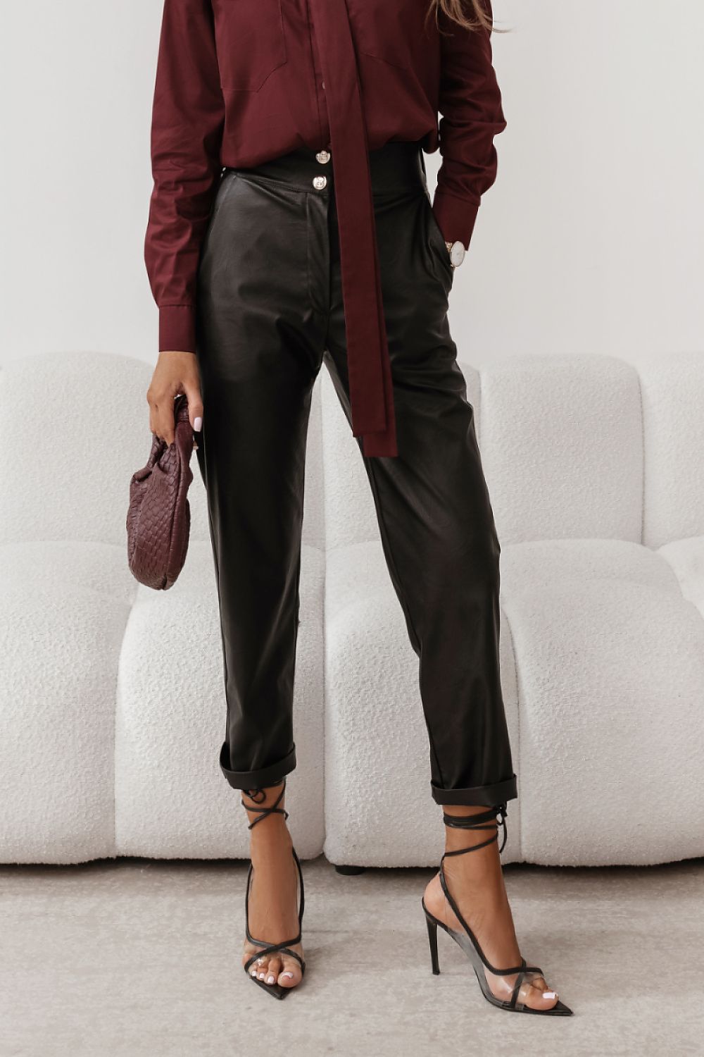 Person wearing a burgundy blouse, black pants, and high-heeled shoes