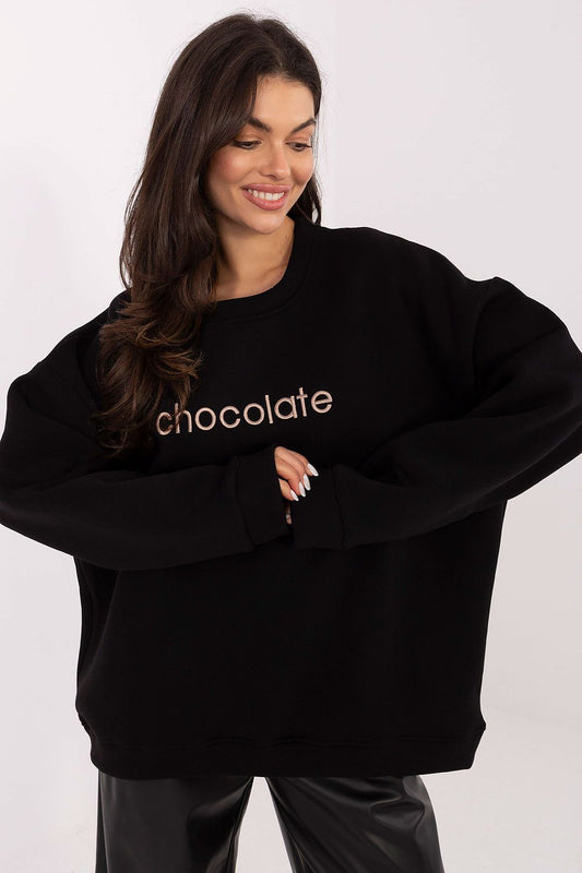 Woman wearing a black sweatshirt with 'chocolate' text 