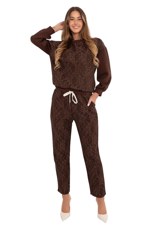 Front view of a model posing in a dark brown tracksuit set featuring lace appliques on the hoodie chest and an adjustable drawstring waistband