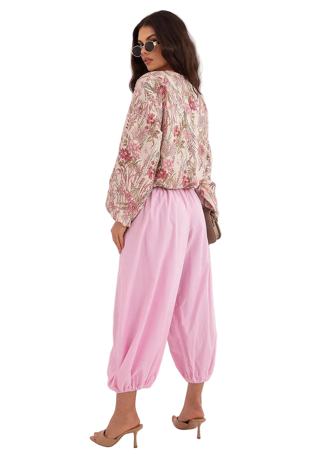 Back view of a woman wearing a pink and white floral long-sleeve blouse with a relaxed drape.