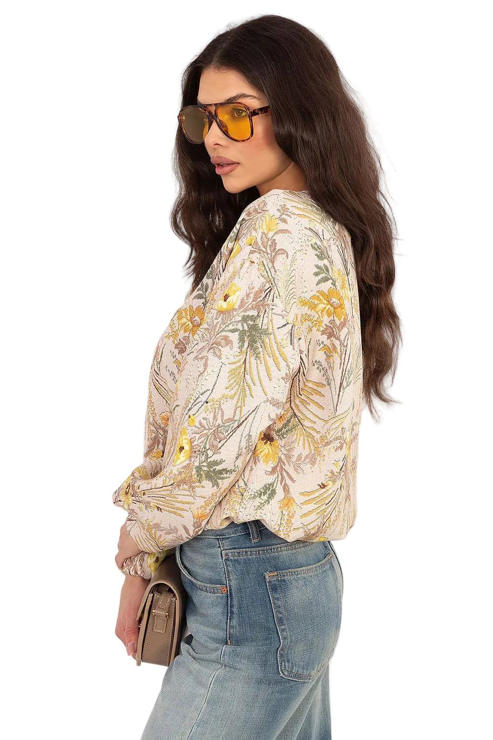 Side-angle view of a woman styling a cream-colored floral satin-finish blouse with denim jeans.