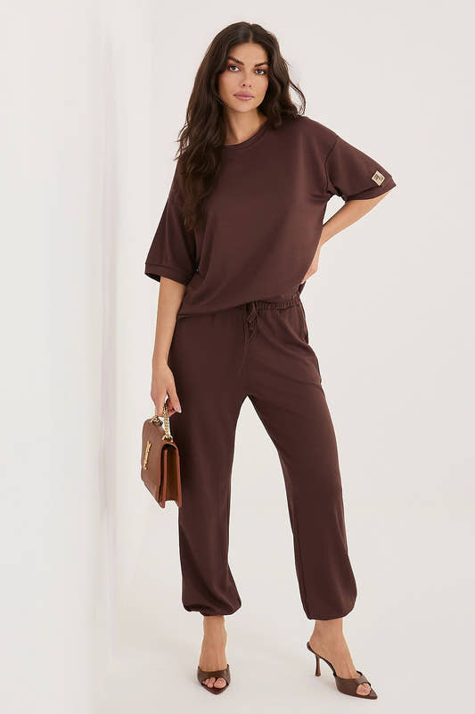 Woman wearing a brown outfit with a plain background