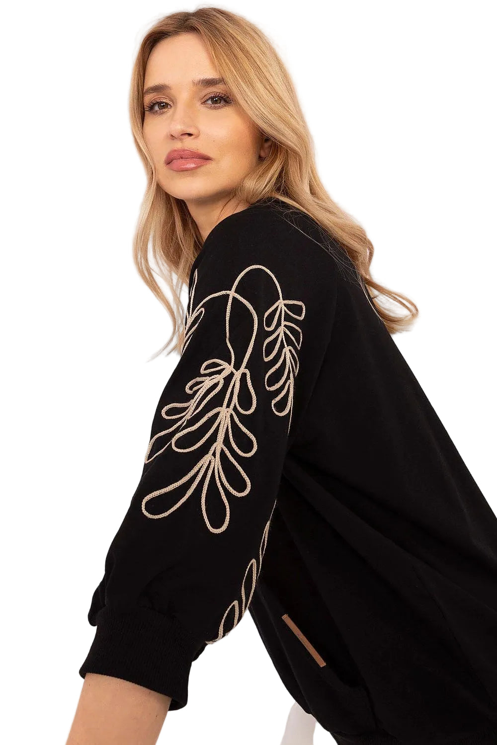 Side profile of a model highlighting the heavy white floral embroidery on a black long-sleeve sweatshirt.