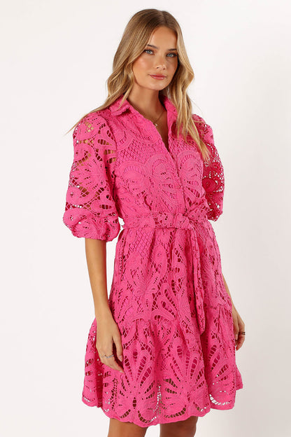 Woman wearing a pink lace dress with short puffy sleeves 