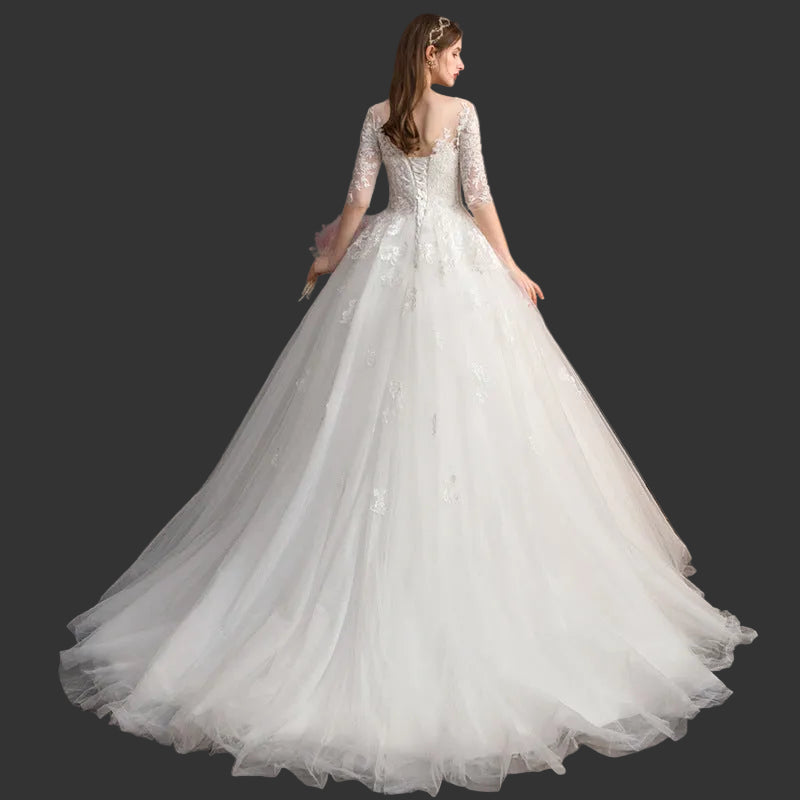 Bride wearing ivory tulle A-line bridal gown with floral lace appliqué bodice and court train

