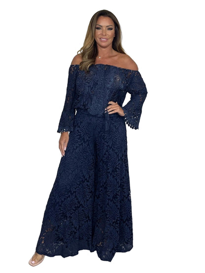 Woman wearing a navy lace off-shoulder top and wide-leg pants 