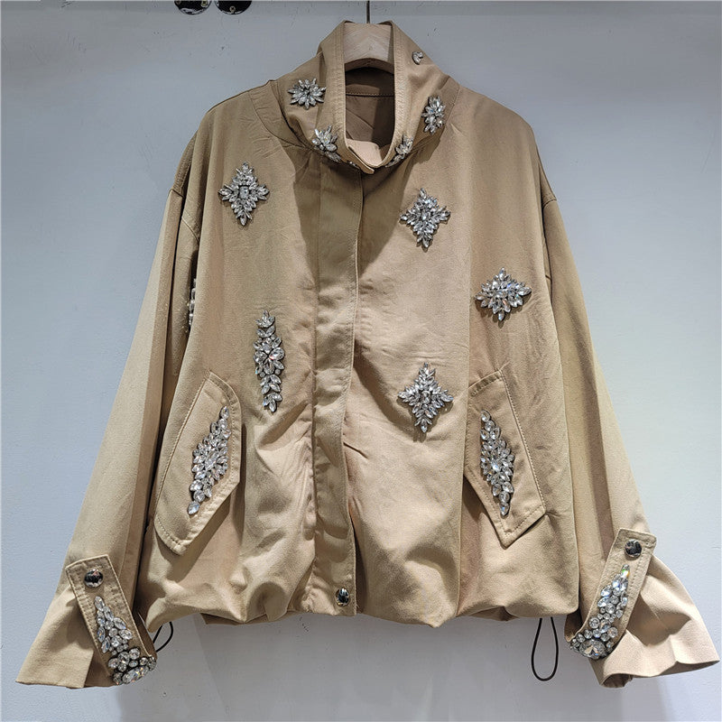 A beige oversized jacket with silver rhinestone embellishments on the front, pockets, and cuffs.