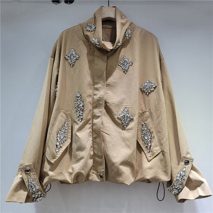 A beige oversized jacket with silver rhinestone embellishments on the front, pockets, and cuffs.