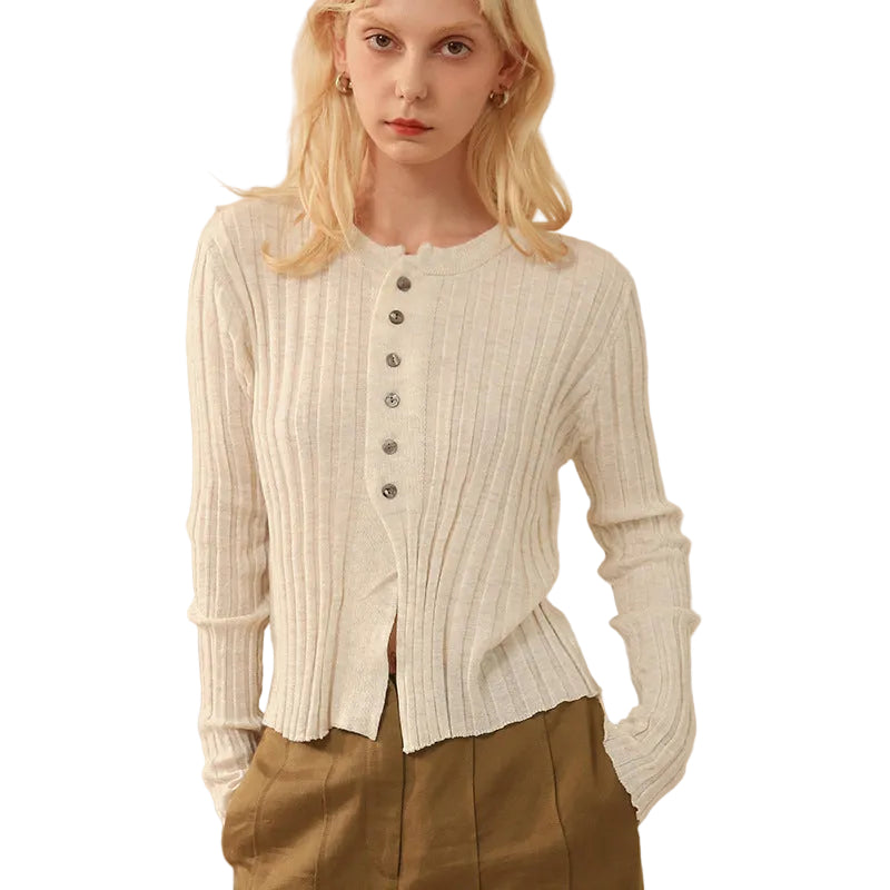Woman wearing a white ribbed sweater with button details 