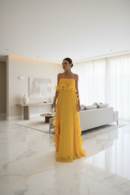 Yellow strapless pleated maxi dress – side view showing cascading ruffle panels and accordion pleating detail