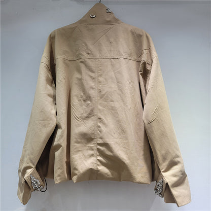 A beige utility jacket with decorative silver rhinestone embellishments on the cuffs,.