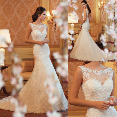 Bride wearing a fitted ivory lace fishtail bridal gown with floral appliqué bodice and chapel train

